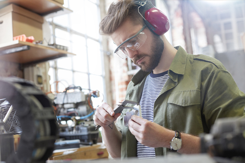 Male designer using caliper in workshop stock photo