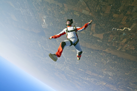 Luftaufnahme eines Mannes beim Fallschirmspringen, lizenzfreies Stockfoto