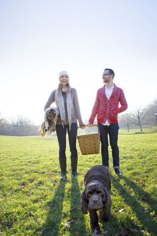 Glückliches Paar steht auf einem Feld gegen den klaren Himmel, lizenzfreies Stockfoto