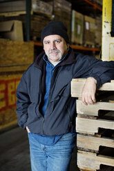 Portrait of confident worker standing at warehouse - CAVF05342