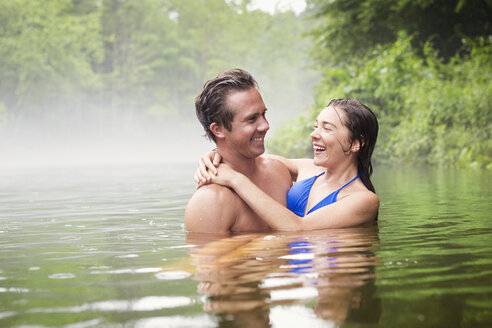Happy couple swimming in lake - CAVF05430
