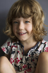 Portrait of girl sitting on sofa at home - CAVF05472