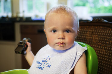 Porträt eines kleinen Jungen, der zu Hause auf einem Hochstuhl sitzt - CAVF05523