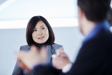 Attentive businesswoman listening to colleagues in meeting - CAIF10662