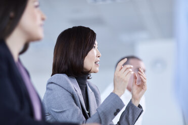 Businesswoman gesturing and explaining in meeting - CAIF10673