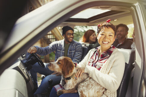 Portrait lächelnde Frau mit Hund auf dem Schoß im Auto mit Freunden - CAIF10704