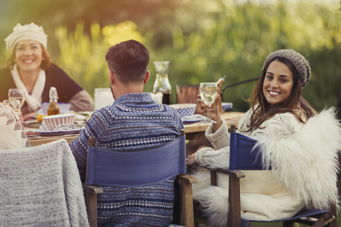 Portrait smiling woman drinking wine at garden lunch table - CAIF10713