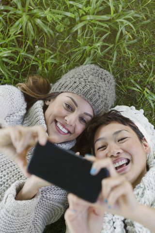 Overhead-Ansicht lächelnd Frauen nehmen Selfie mit Kamera-Handy im Gras, lizenzfreies Stockfoto