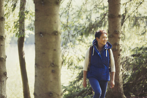 Lächelnde Frau beim Wandern im Wald - CAIF10746