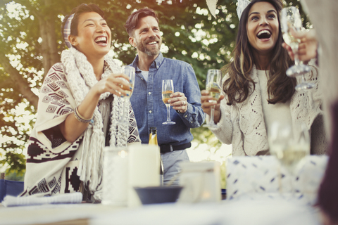 Freunde lachen und trinken Champagner auf einer Geburtstagsparty, lizenzfreies Stockfoto