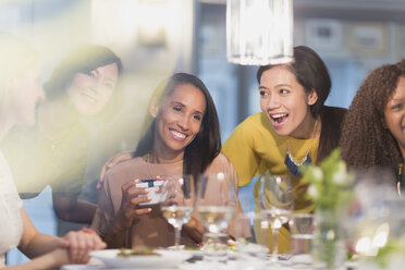 Lächelnde Freundinnen feiern Geburtstag am Restauranttisch - CAIF10769