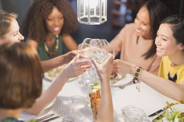 Lächelnde Frauen Freunde Toasting Weißwein Gläser Essen im Restaurant Tisch - CAIF10785