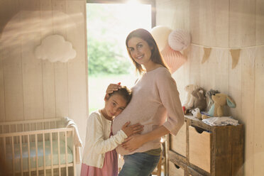 Porträt lächelnd schwangere Mutter und Tochter im Kinderzimmer - CAIF10842