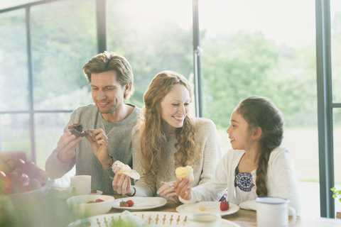 Familie isst Cupcakes am Tisch, lizenzfreies Stockfoto