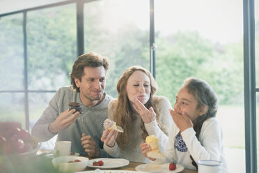 Familie isst Cupcakes am Tisch - CAIF10880