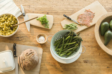 Blick von oben auf Lachs, Spargel, Nudeln, Brot und Butter auf dem Esstisch - CAIF10895