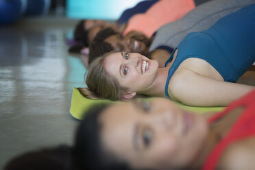 Porträt lächelnd Frauen üben Brücke Pose in Yoga-Klasse Fitness-Studio - CAIF10950