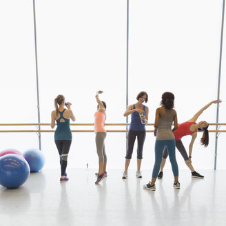 Frauen dehnen sich und trinken Wasser im Fitnessstudio - CAIF10981