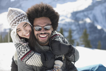 Porträt eines glücklichen Paares, das sich im Schnee umarmt - CAIF10995