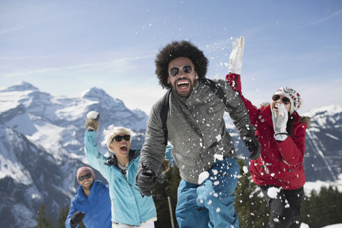 Friends enjoying snowball fight at mountain - CAIF11000