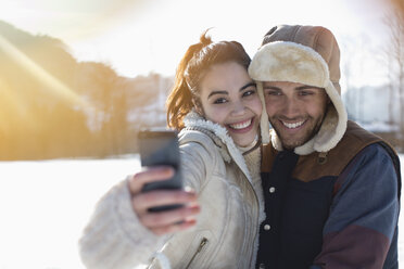 Couple taking selfie in snow - CAIF11001