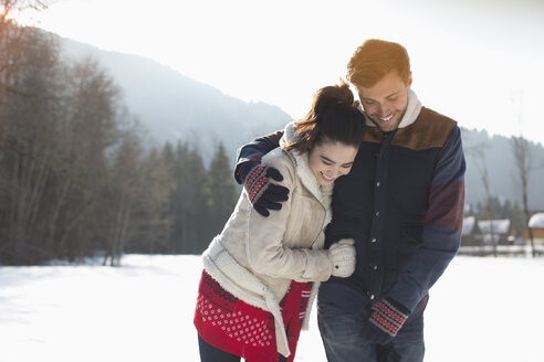 Glückliches Paar beim Spaziergang im Schnee - CAIF11014