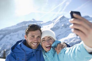 Couple taking selfie in snow - CAIF11015