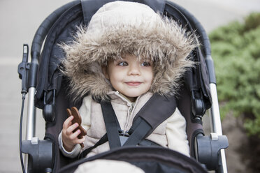 Lächelndes Mädchen mit Fellkapuze im Kinderwagen - CAIF11059