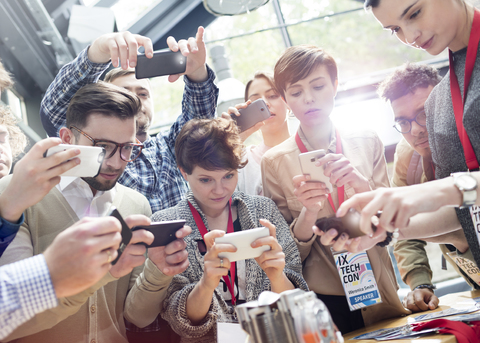 Menschenmenge mit Kameratelefonen auf Technologiekonferenz, lizenzfreies Stockfoto