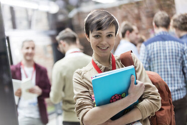 Portrait smiling female college student with backpack and laptop - CAIF11095