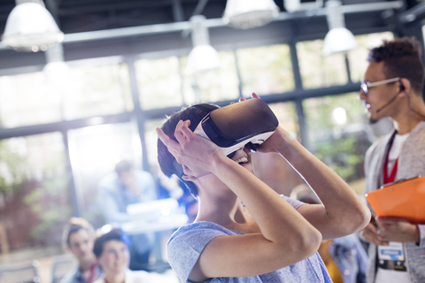 Frau probiert Virtual-Reality-Stimulator-Brille auf Technologiekonferenz aus, lizenzfreies Stockfoto