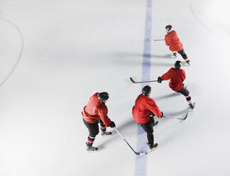 Eishockeymannschaft in roten Uniformen beim Schlittschuhlaufen auf dem Eis - CAIF11144