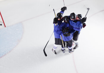 Hockey team in blue uniforms cheering celebrating on ice - CAIF11145