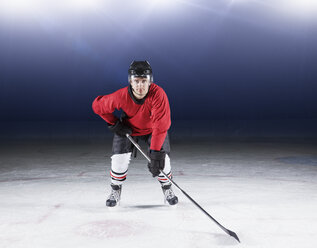 Portrait determined hockey player in red uniform on ice - CAIF11148