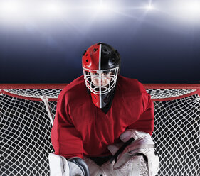Portrait determined hockey goalie protecting goal net - CAIF11150