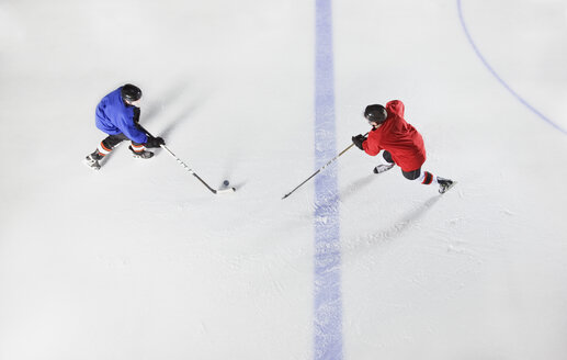 Draufsicht auf Eishockeyspieler, die um den Puck auf dem Eis kämpfen - CAIF11156