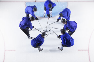 Eishockeyspieler in blauen Trikots drängen sich um den Puck auf dem Eis - CAIF11165