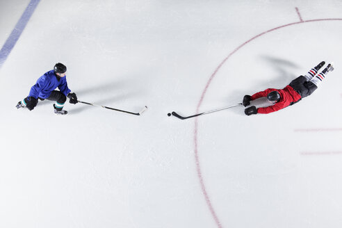 Draufsicht auf Eishockeyspieler, die nach dem Puck auf dem Eis tauchen - CAIF11177