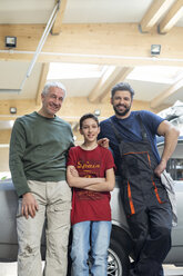 Porträts lächelnde Mehrgenerationen-Mechanikerfamilie in Autowerkstatt - CAIF11242