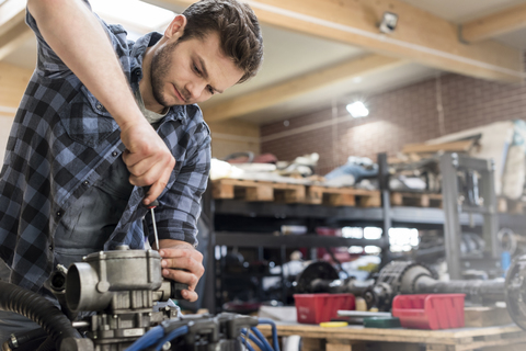 Mechaniker repariert Automotor in Autowerkstatt, lizenzfreies Stockfoto