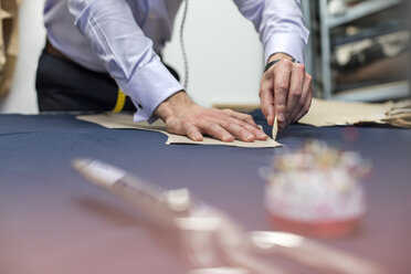 Tailor marking fabric in menswear workshop - CAIF11288