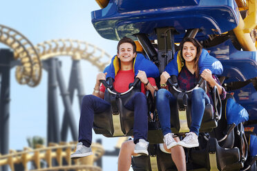 Young couple riding amusement park ride - CAIF11301