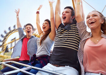 Cheering friends riding amusement park ride - CAIF11316