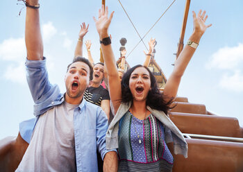 Portrait enthusiastic friends cheering on amusement park ride - CAIF11319