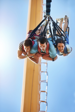 Freunde beim Bungee-Springen im Vergnügungspark, lizenzfreies Stockfoto