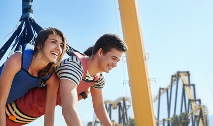 Enthusiastic friends bungee jumping at amusement park - CAIF11334