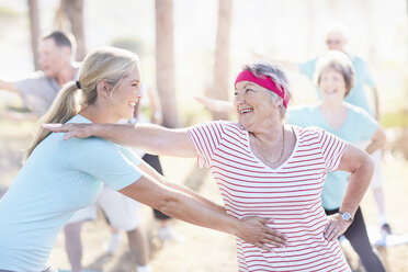 Yoga instructor helping senior woman - CAIF11361