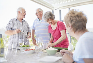 Senior couples preparing patio lunch - CAIF11367