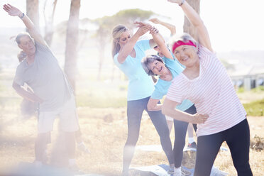 Ältere Erwachsene üben Yoga im sonnigen Park - CAIF11372