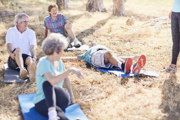 Ältere Erwachsene üben Yoga im sonnigen Park - CAIF11376